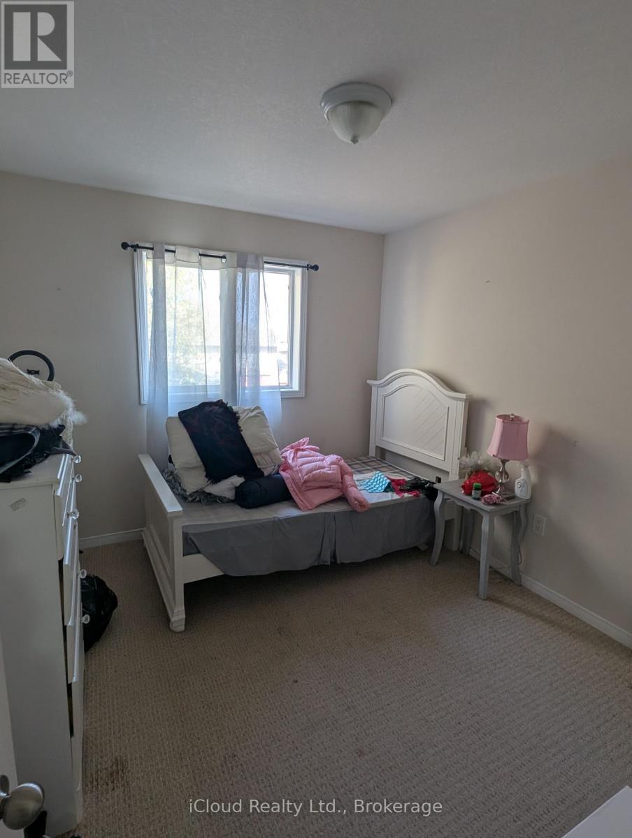 A bedroom with a bed, a dresser, and a window.