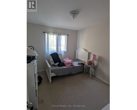 A bedroom with a bed, a dresser, and a window.