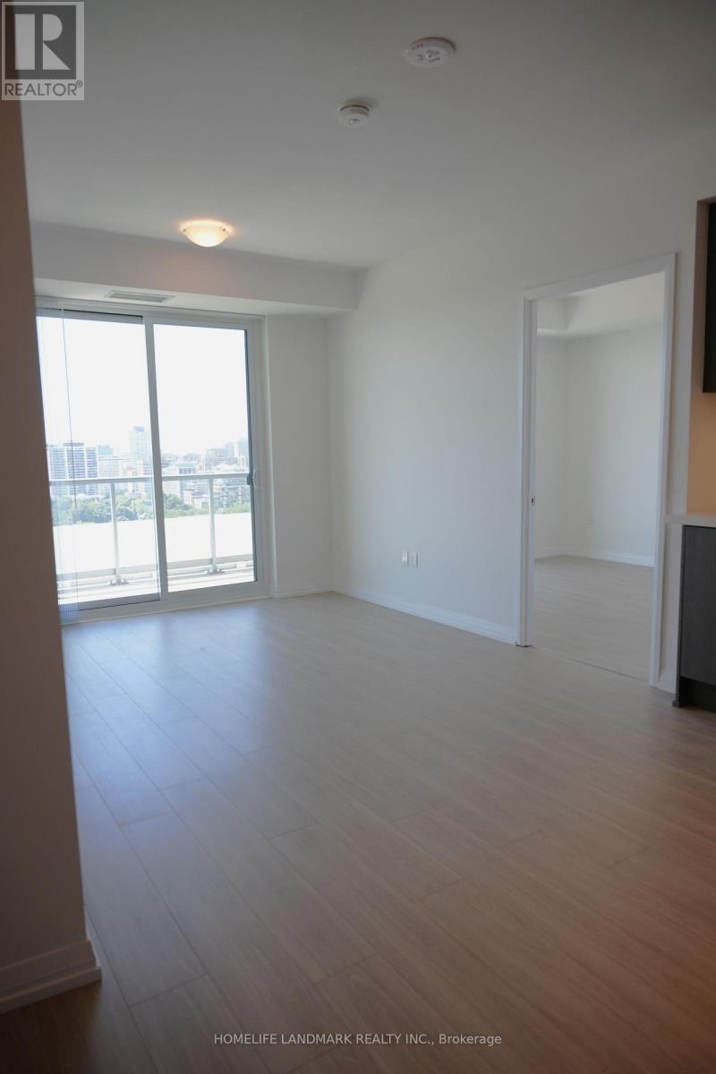 A large empty room with wooden floors and a sliding glass door.