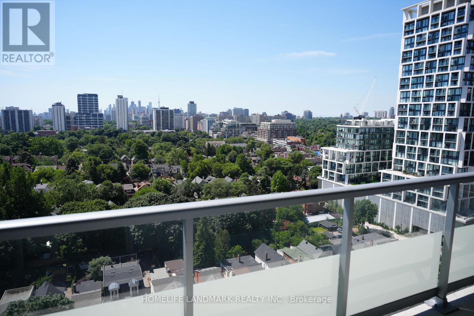 A balcony overlooks a cityscape with a mix of residential and commercial buildings.