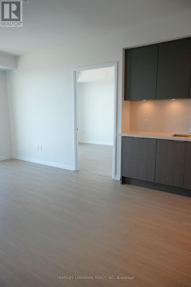 A room with a white door and a counter with cabinets.