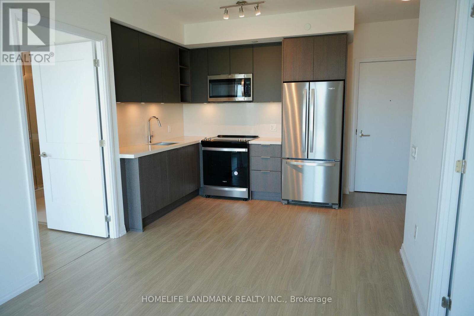 A kitchen with a stove top oven and a refrigerator.