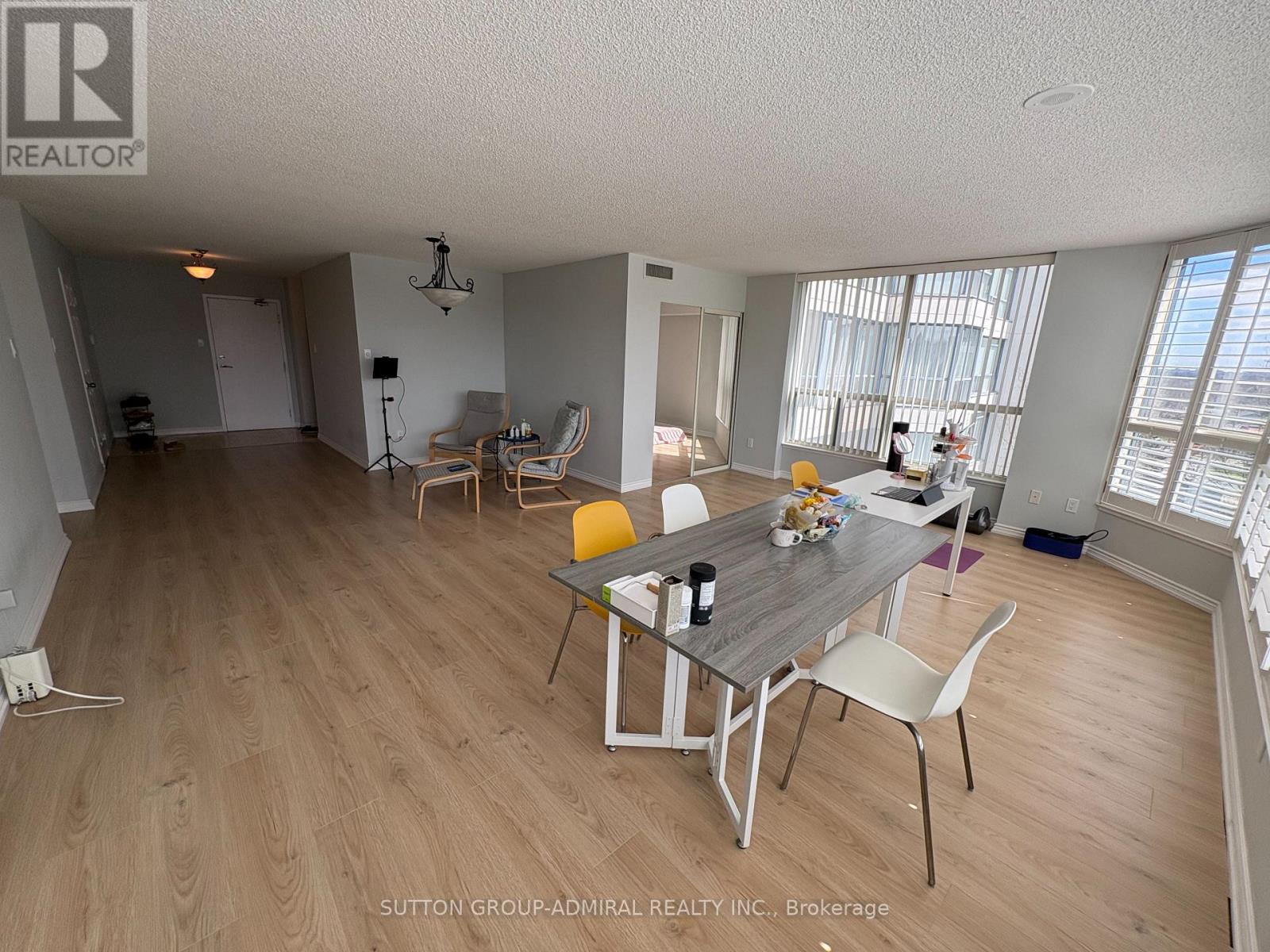 A dining room with a table set for two and chairs around it.