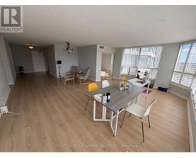 A dining room with a table set for two and chairs around it.