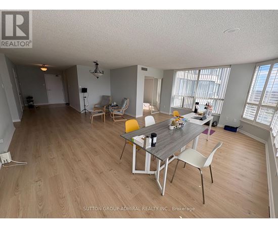 A dining room with a table set for two and chairs around it.