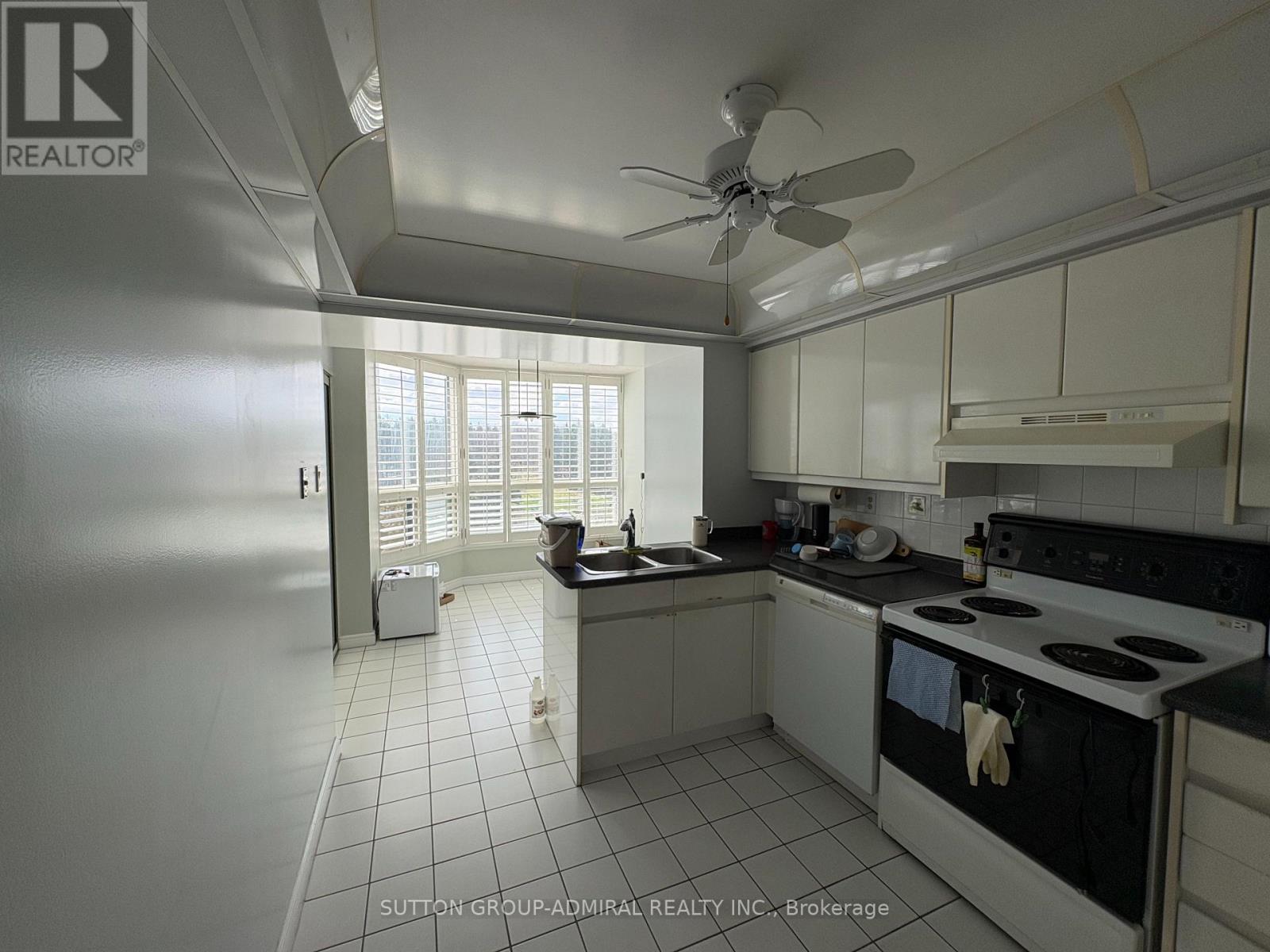 A kitchen with white cabinets and a black stove top oven.