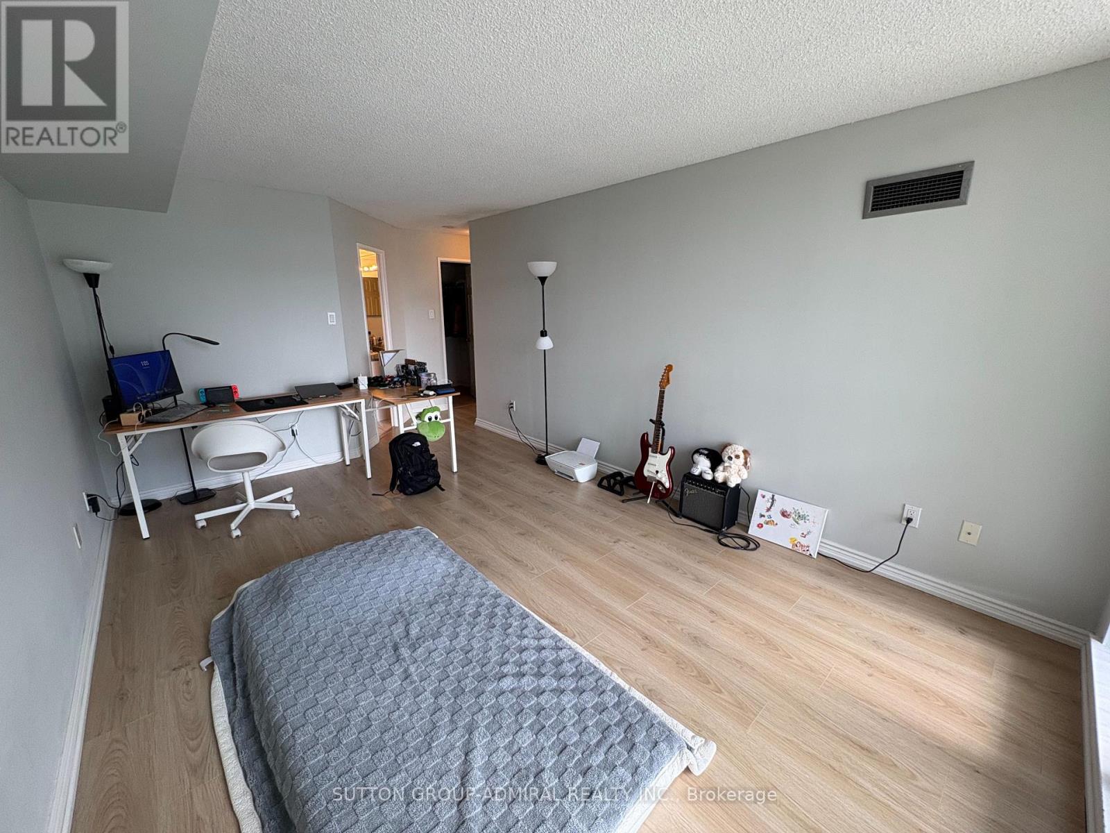A bedroom with a bed, desk, and chair.