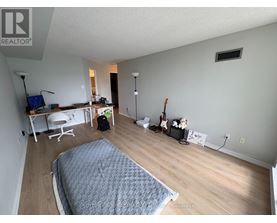 A bedroom with a bed, desk, and chair.