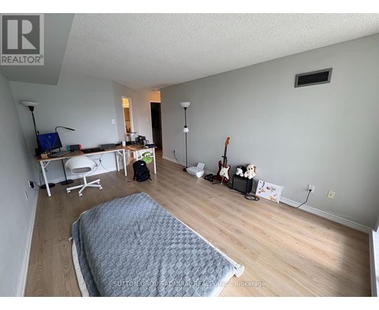A bedroom with a bed, desk, and chair.
