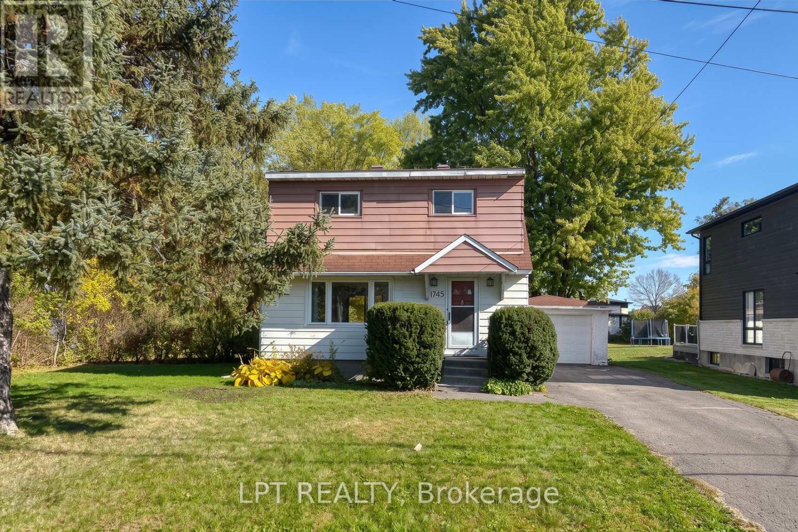 A house with a brown roof and a white front porch is for sale.