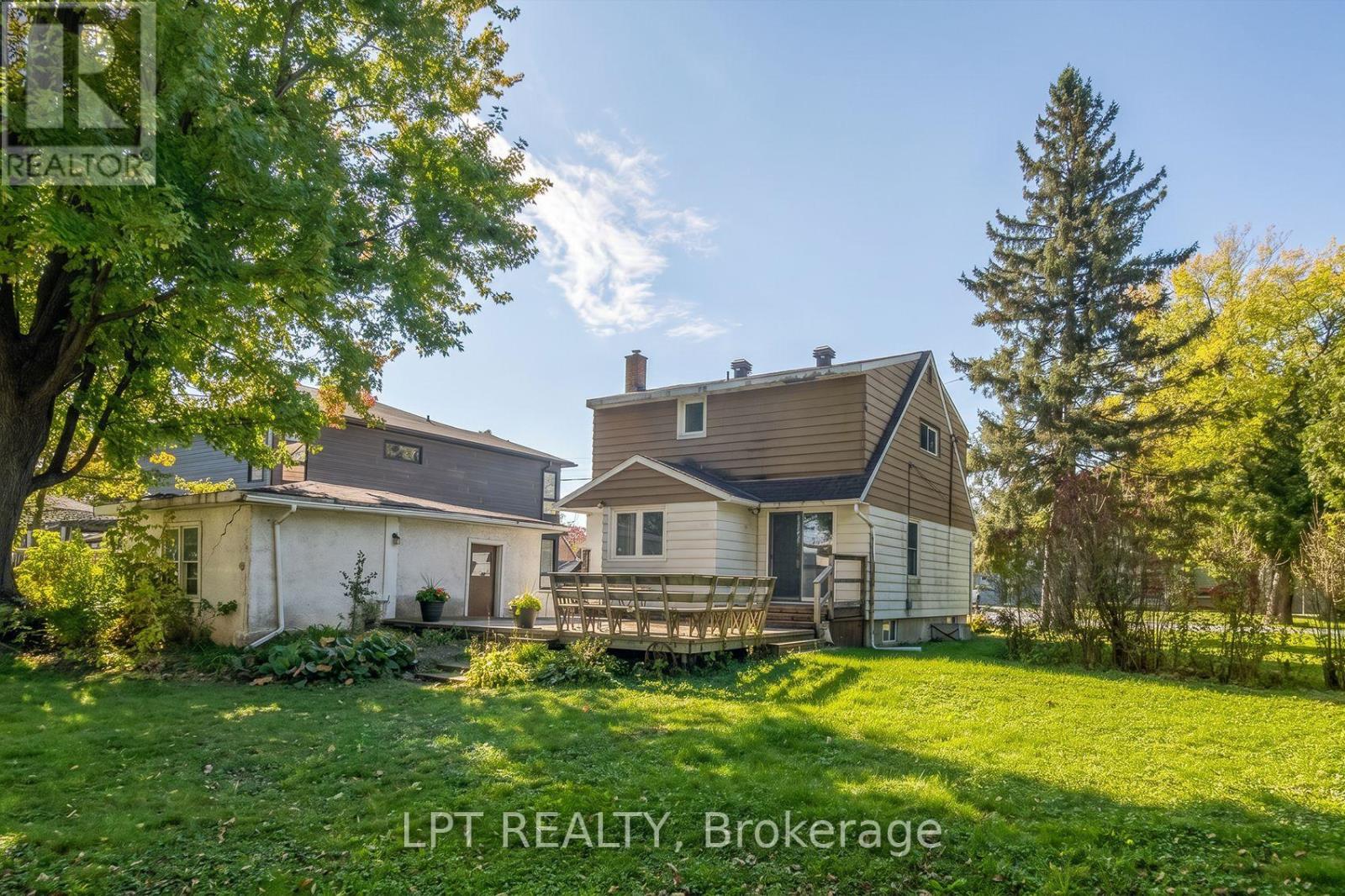A house with a well-maintained lawn and trees in the background.