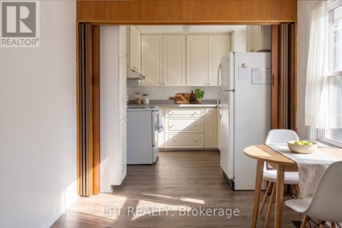 A kitchen with a table and chairs is visible through an open door.
