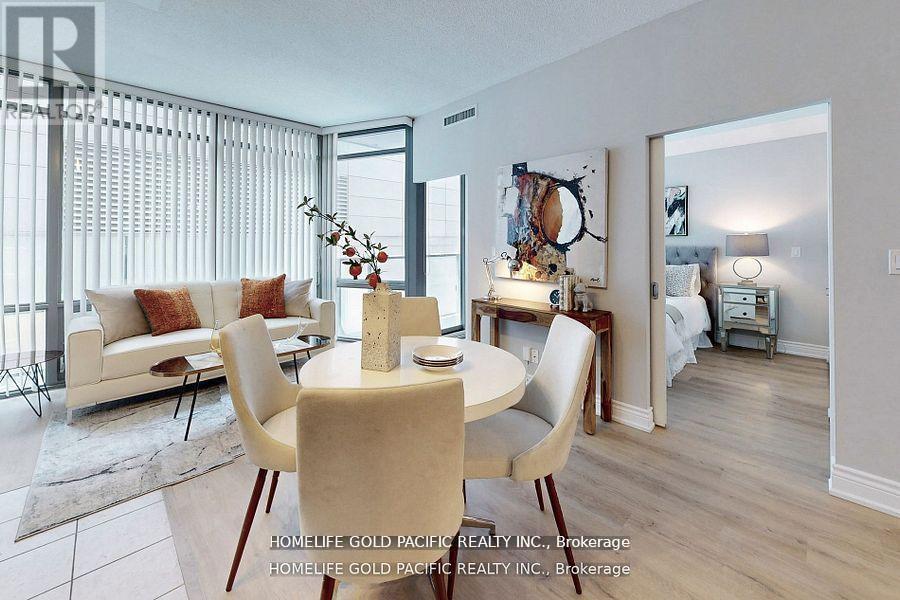 A dining room with a table set for two and a couch with pillows.