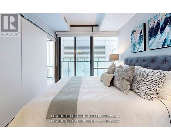 A bedroom with a large bed and a painting on the wall.