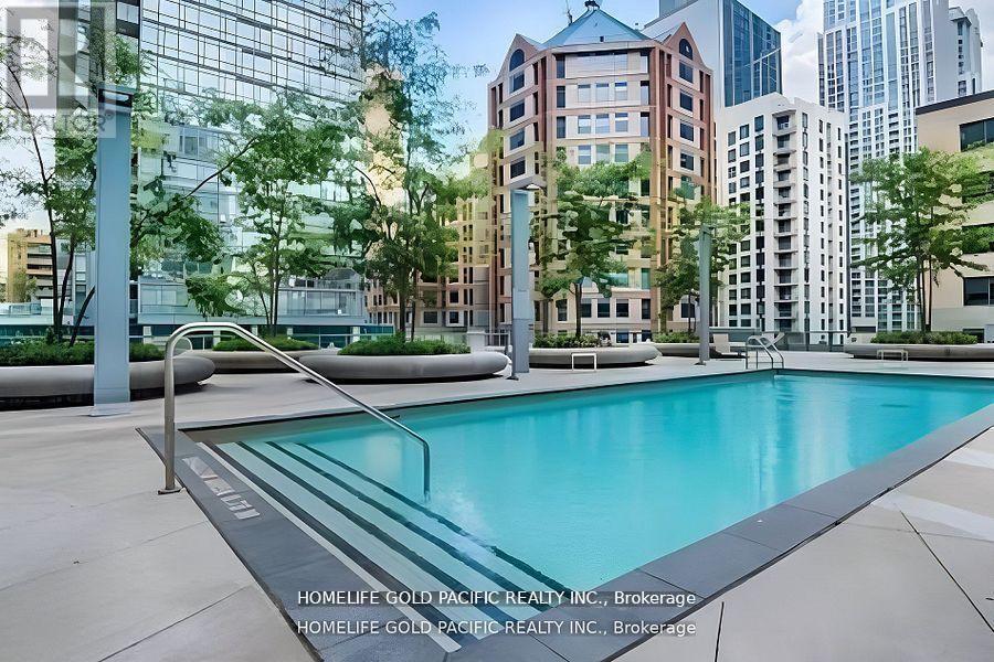 A pool in a city surrounded by buildings.