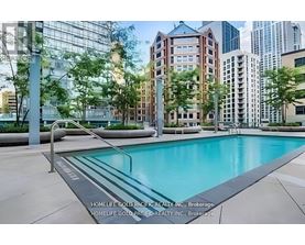 A pool in a city surrounded by buildings.
