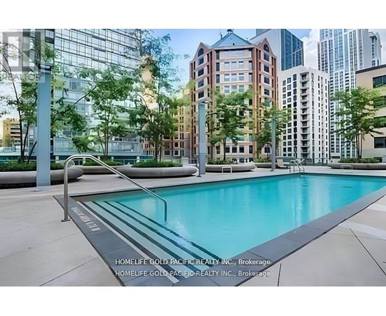 A pool in a city surrounded by buildings.