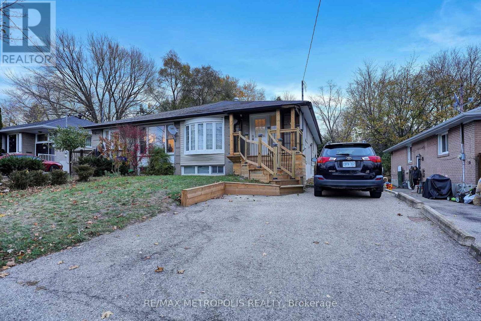 A car is parked in a driveway with a house in the background.