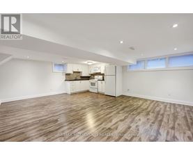 A spacious room with wooden flooring and white walls.