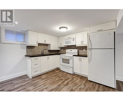 A kitchen with white appliances and wooden floors.