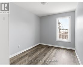 A room with a window showing a view of trees and a building outside.
