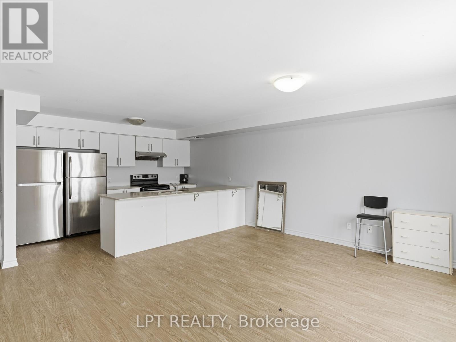 A kitchen with white cabinets and a stainless steel refrigerator.