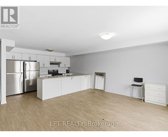 A kitchen with white cabinets and a stainless steel refrigerator.