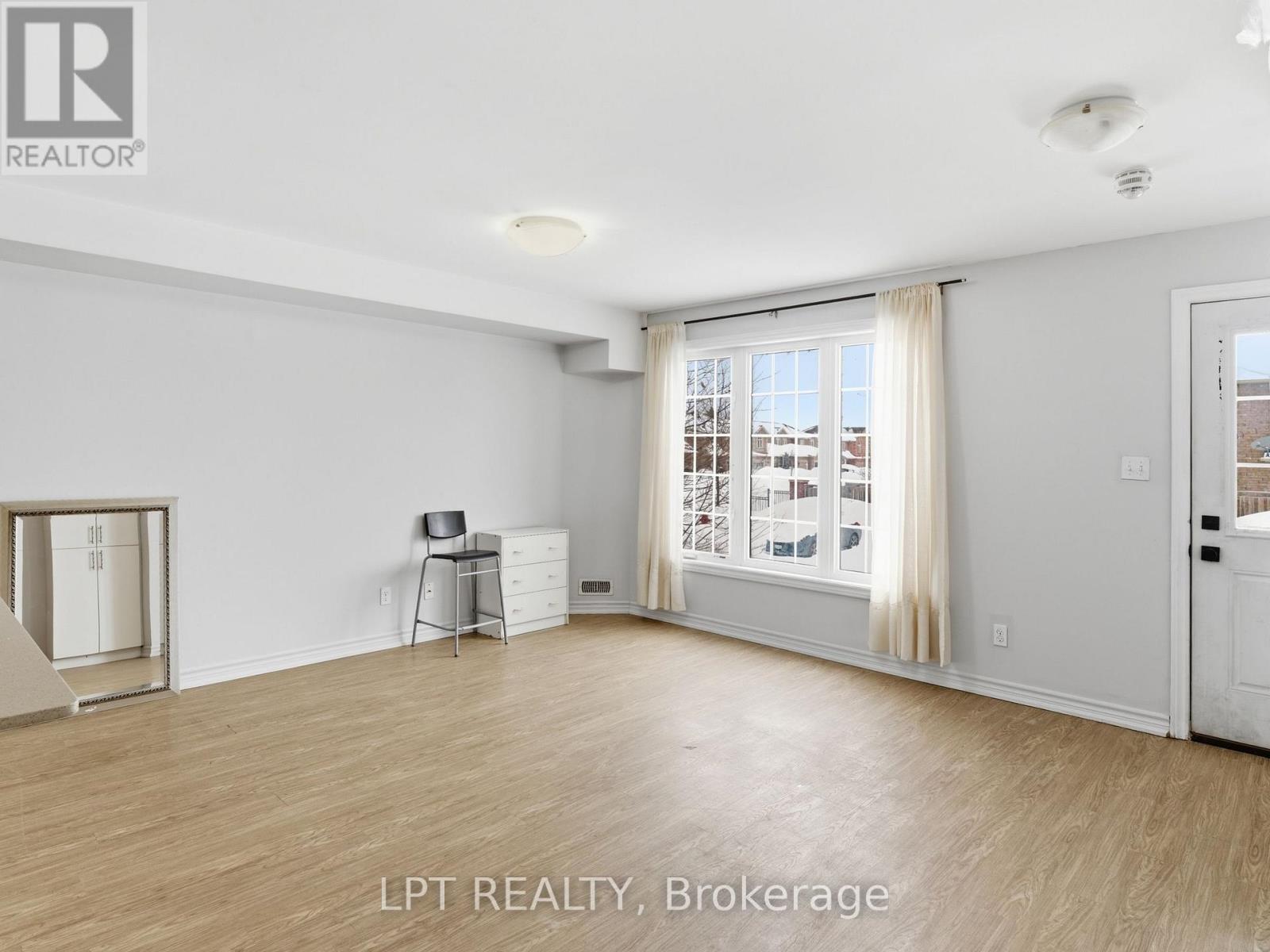 A spacious room with a sliding glass door leading to a balcony.