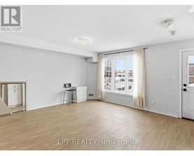 A spacious room with a sliding glass door leading to a balcony.