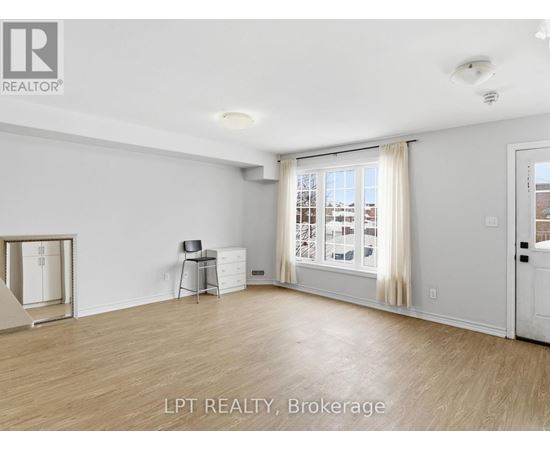 A spacious room with a sliding glass door leading to a balcony.