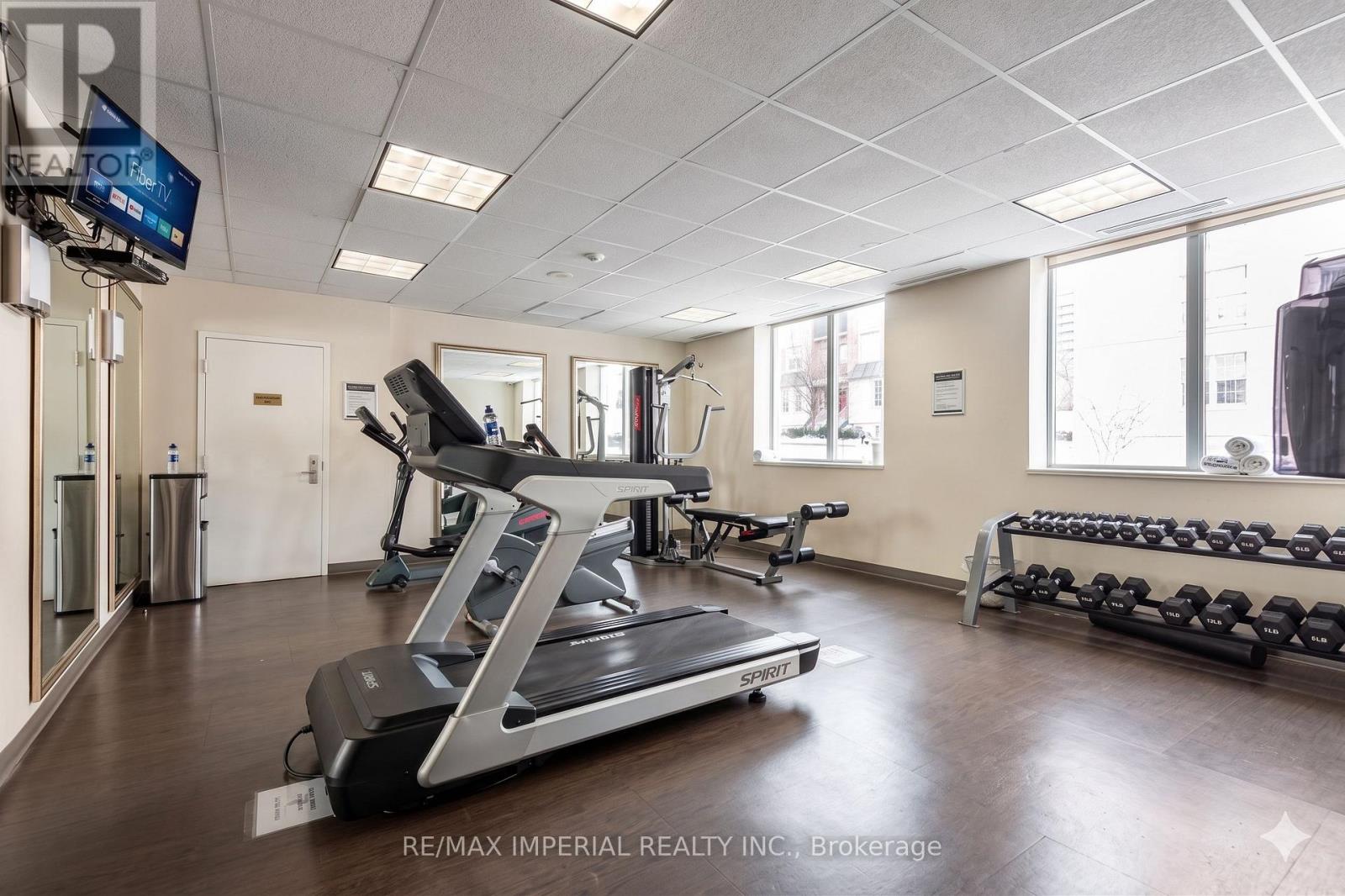 A gym room with a treadmill, weights, and exercise equipment.