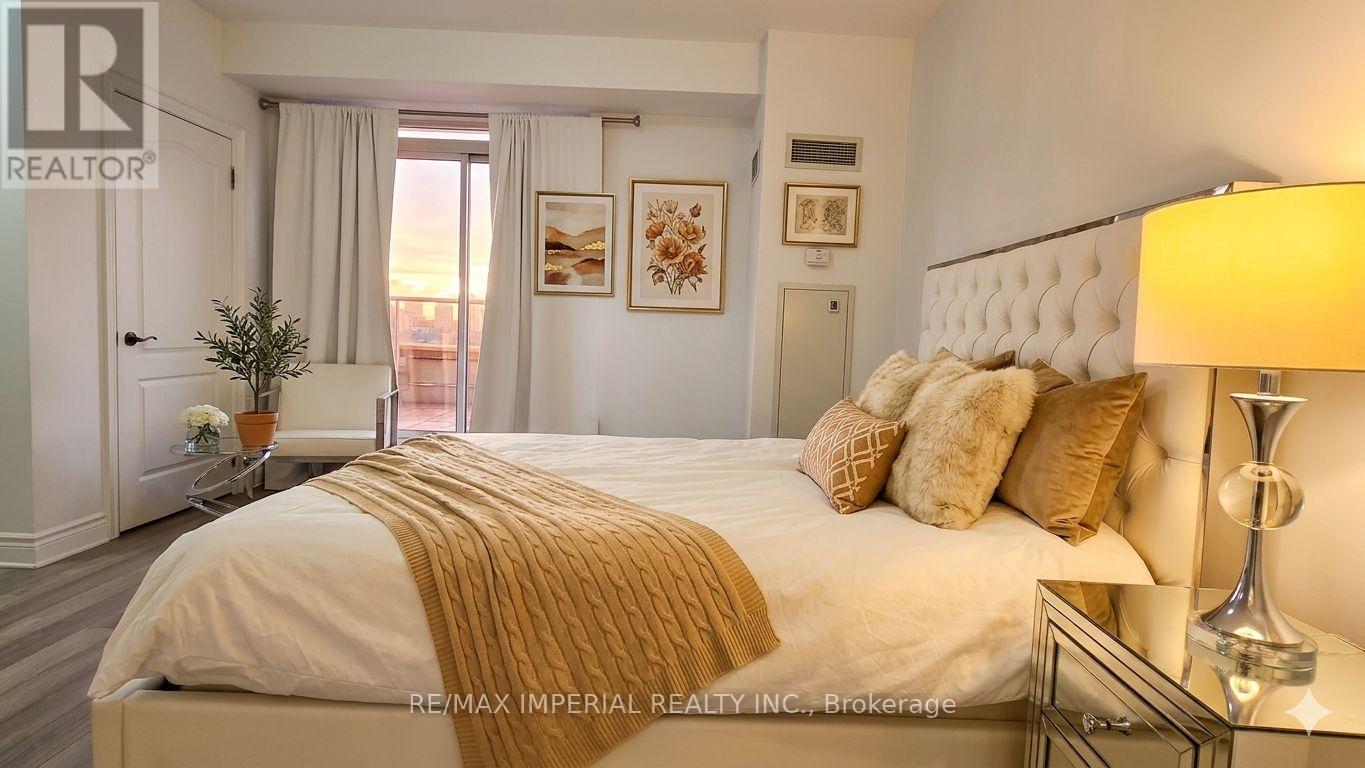 A bedroom with a large bed and a lamp on the nightstand.