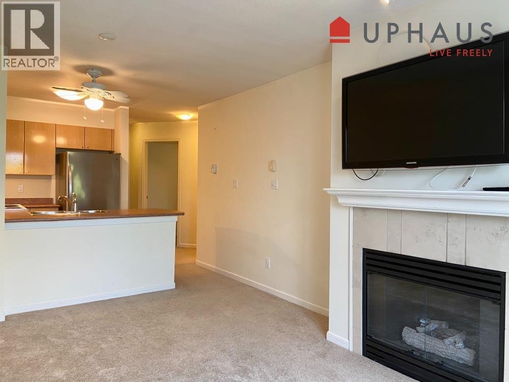 A living room with a fireplace and a flat screen TV mounted on the wall.