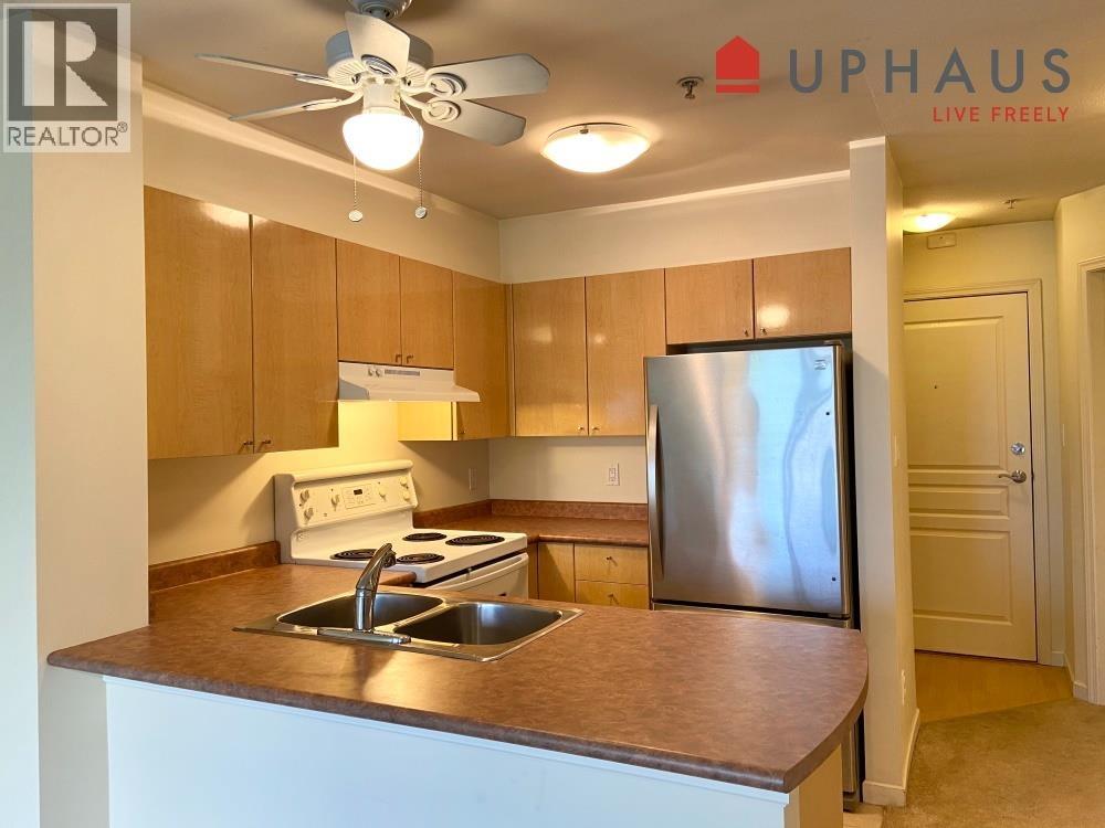 A kitchen with a stove top oven and a refrigerator.
