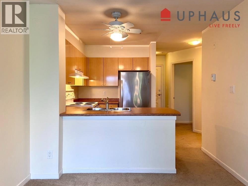 A kitchen with a white counter and a refrigerator.