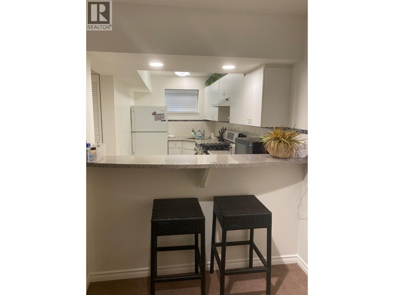 A small kitchen with a bar stool.