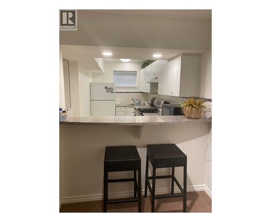 A small kitchen with a bar stool.