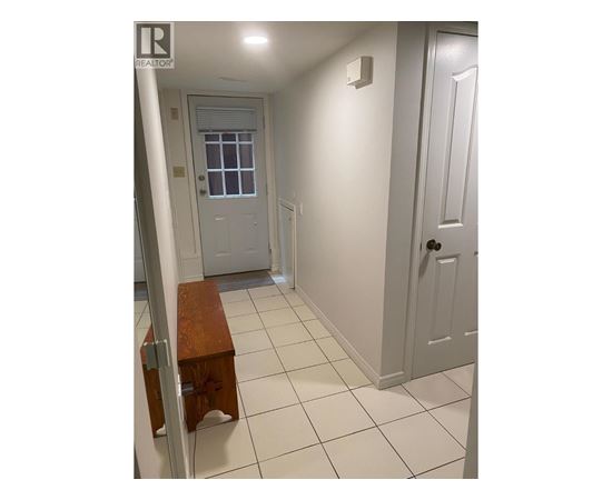 A hallway with a bench and two doors.