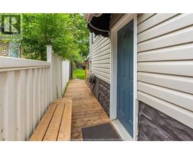 A house with a blue door and a wooden deck.