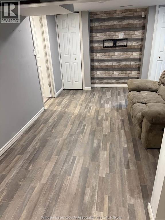 A living room with a grey couch and a wooden floor.
