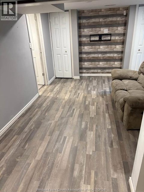 A living room with a grey couch and a wooden floor.