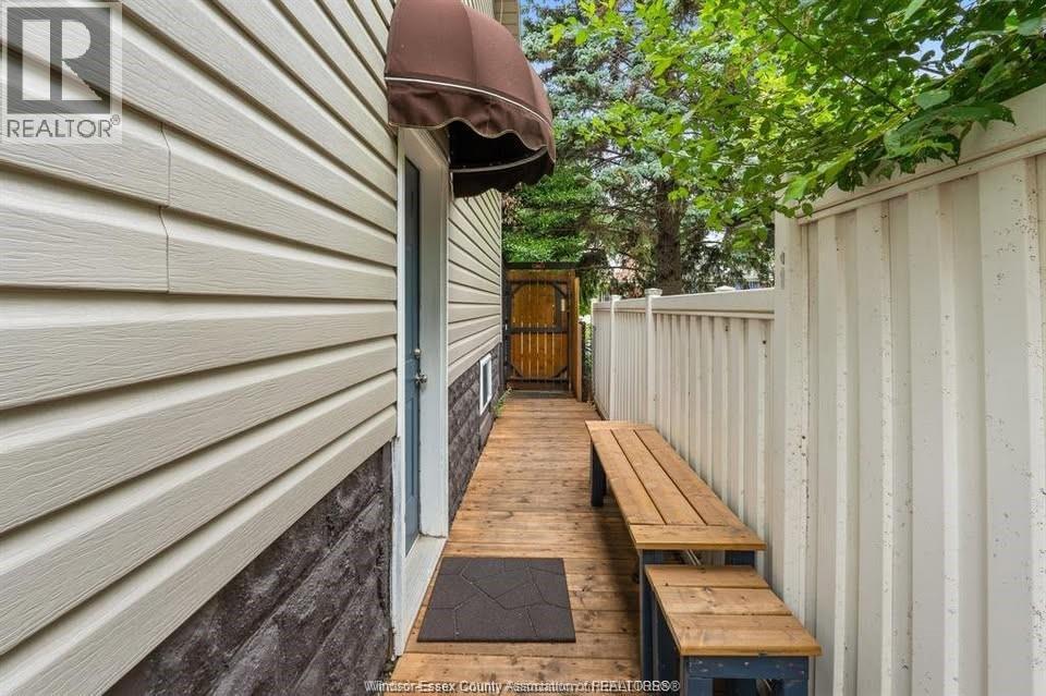 A wooden bench is placed on a wooden platform outside a house.