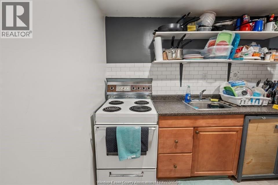 A kitchen with a stove top oven and a sink.
