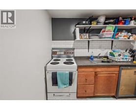 A kitchen with a stove top oven and a sink.