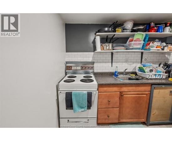 A kitchen with a stove top oven and a sink.