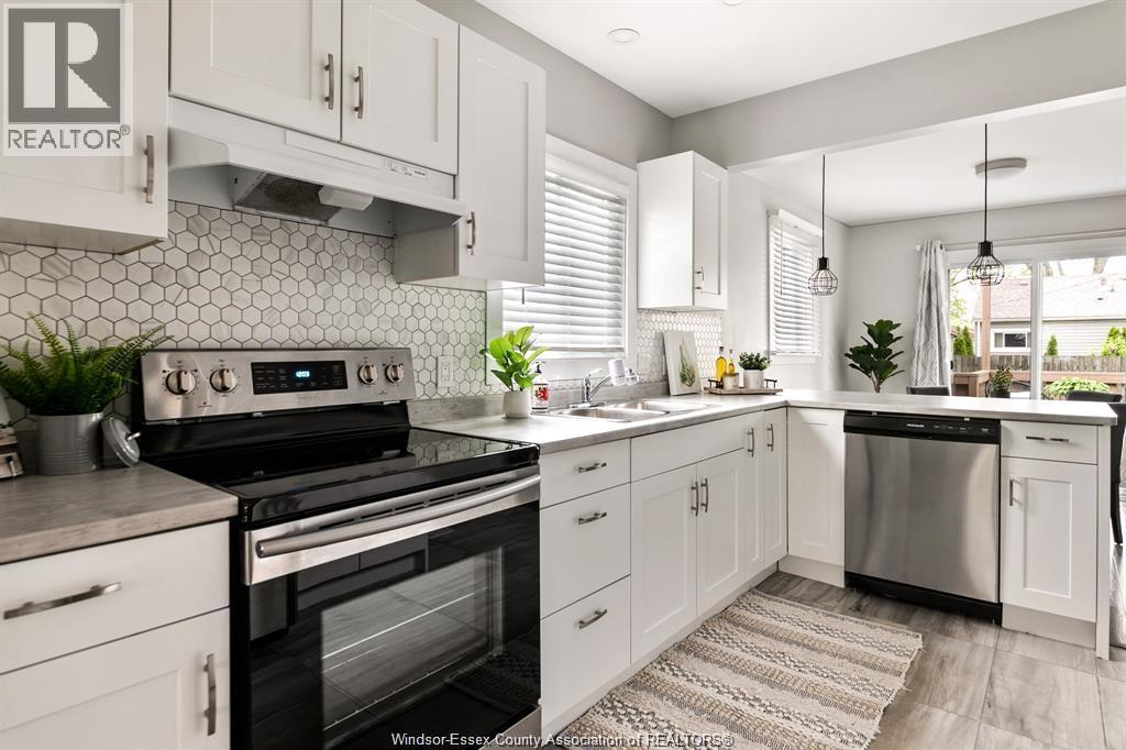 A kitchen with white cabinets and a black stove top oven.