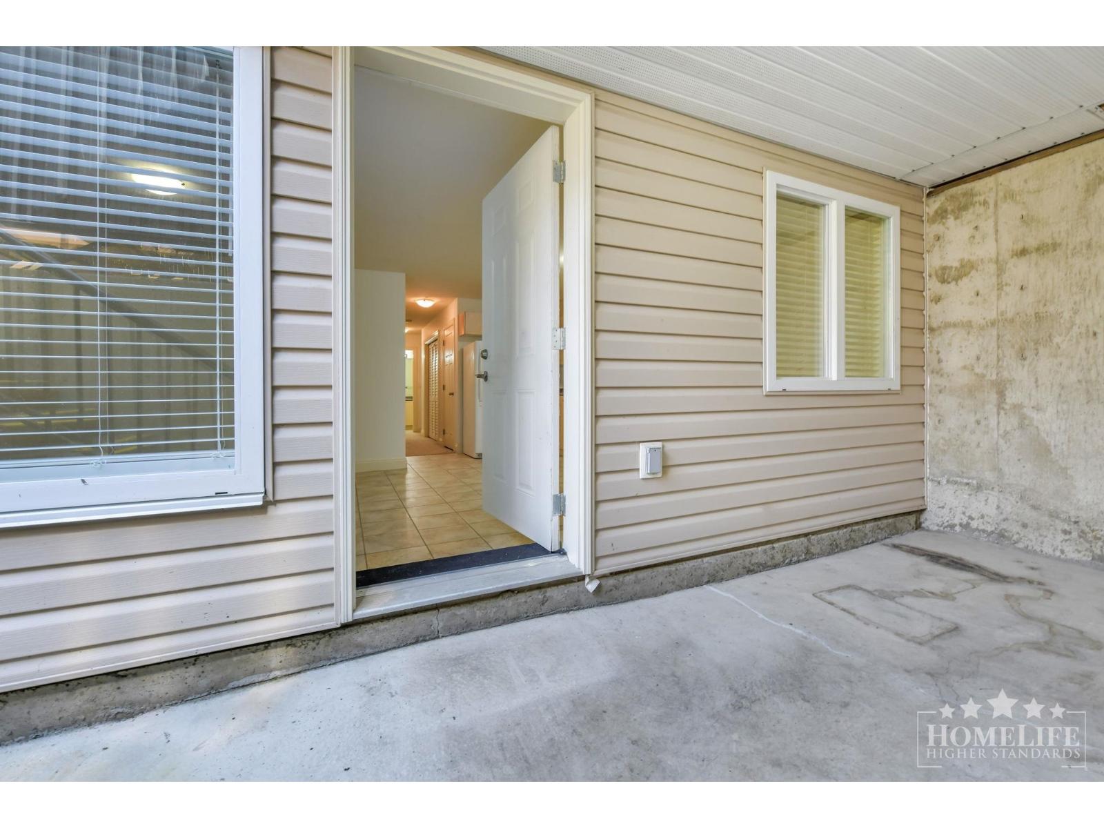 A view of a home's front porch with a door open.