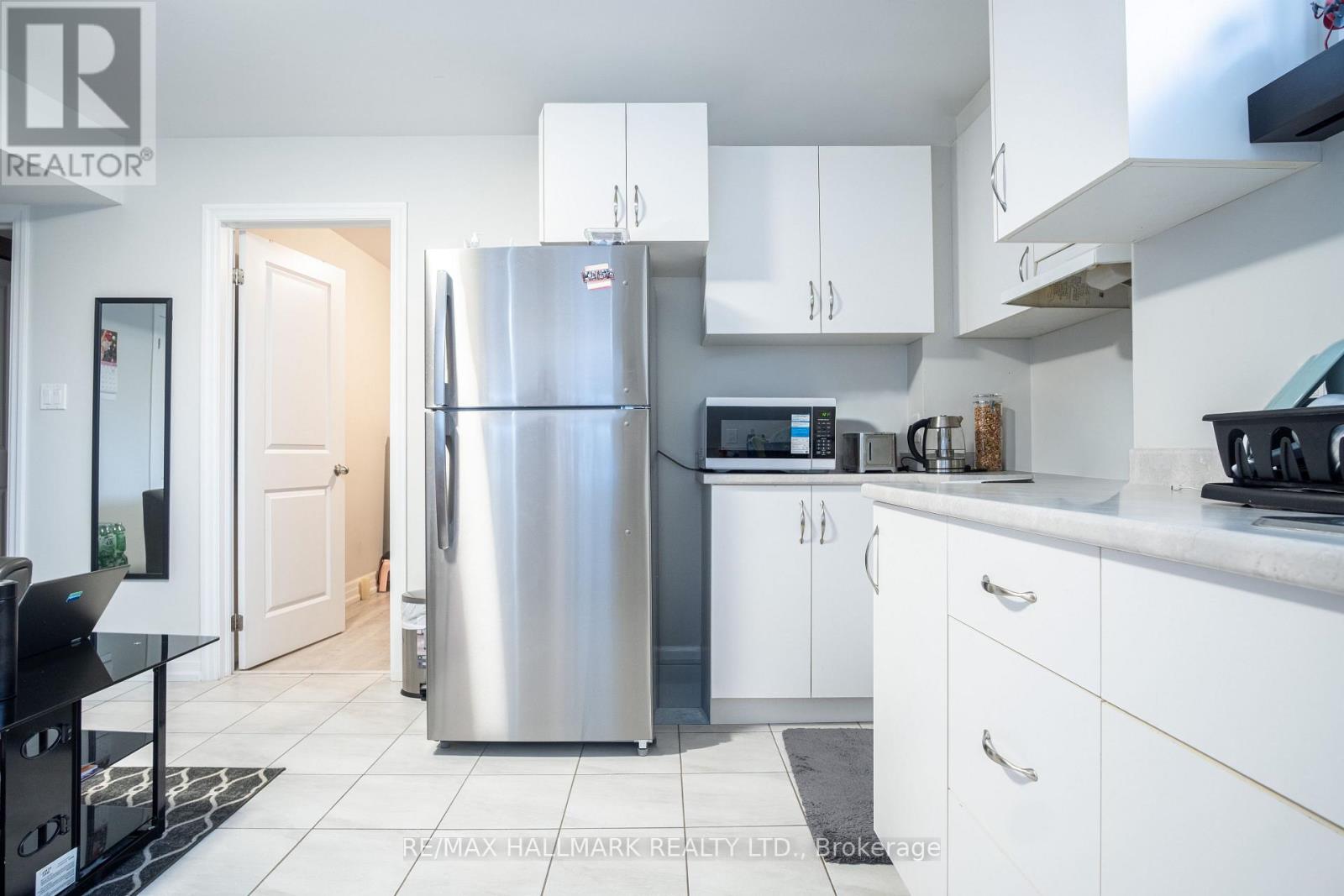 A kitchen with a refrigerator, microwave, and oven.