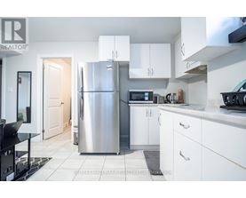 A kitchen with a refrigerator, microwave, and oven.