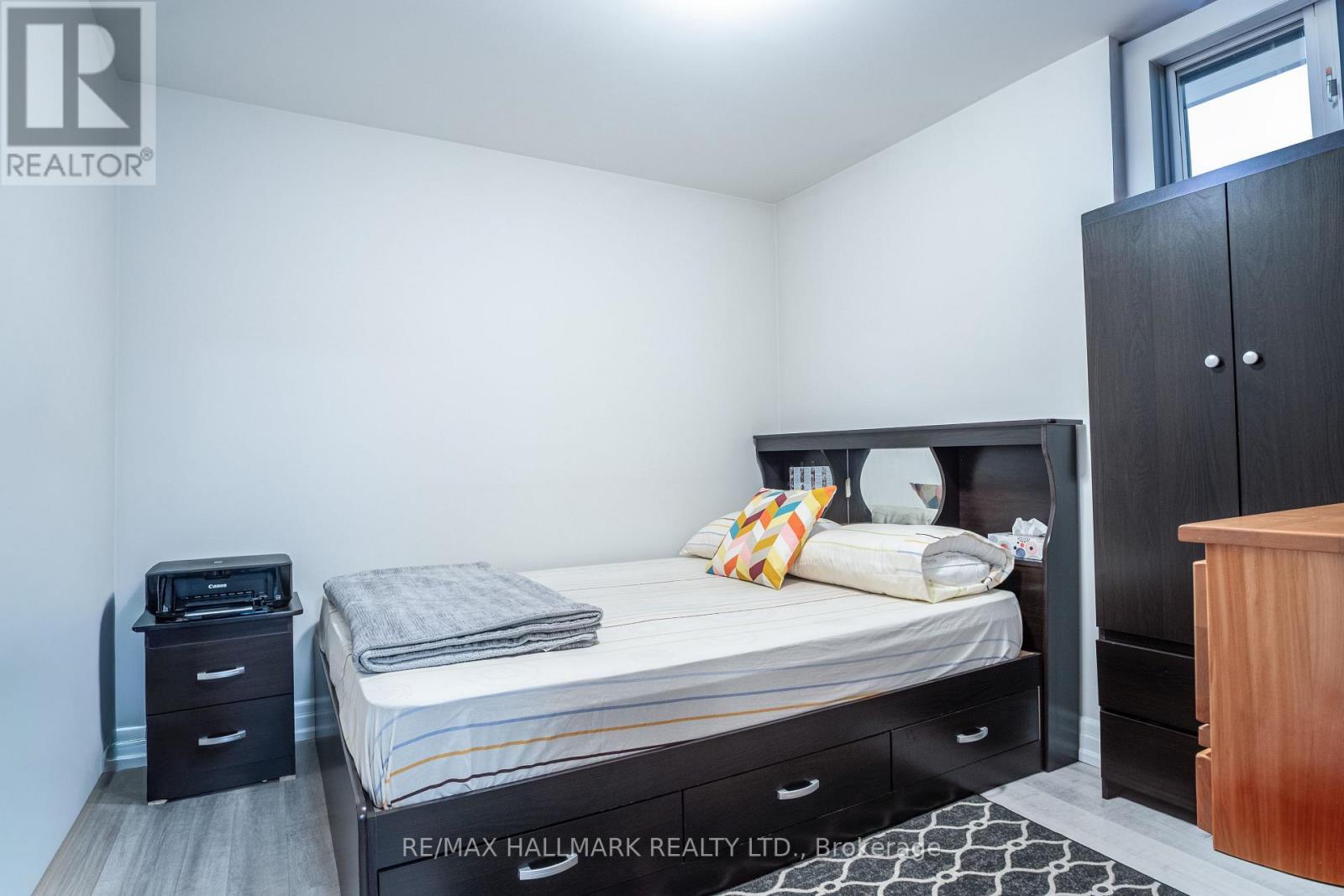 A bedroom with a bed, nightstand, and wardrobe.